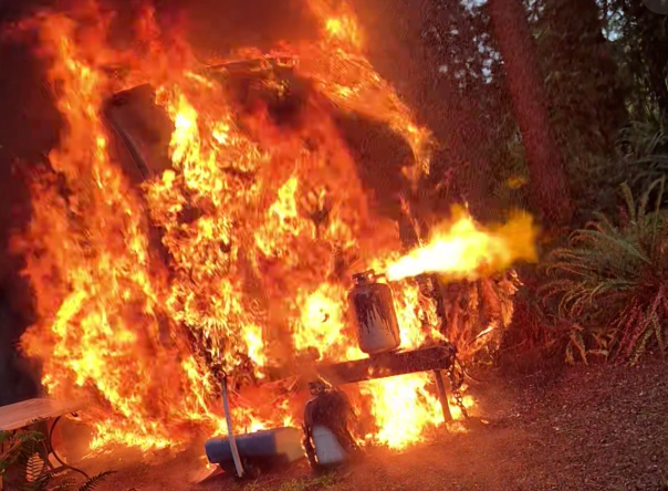 Un tráiler de viaje arde por completo en el parque Lake Connor, mientras un tanque de propano visible en la imagen emite fuego entre las llamas — Imagen: Cuerpo regional de bomberos y rescate de Snohomish 