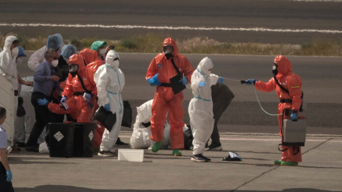 Hondius - Hantavirus - AP Pasajeros son rociados con desinfectante por funcionarios del gobierno español antes de abordar un avión después de desembarcar del crucero MV Hondius afectado por el hantavirus en el aeropuerto de Tenerife en las Islas Canarias, España