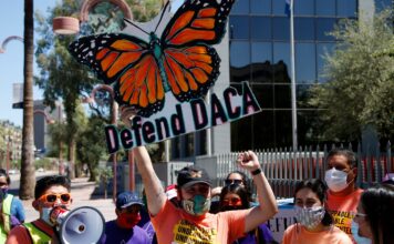 Retrasos en renovaciones de DACA generan preocupación entre beneficiarios Manifestantes se reúnen frente al edificio del Servicio de Inmigración y Control de Aduanas de Estados Unidos (ICE) en Phoenix mientras sostienen una protesta en defensa de DACA, luego de que la Corte Suprema determinara que la administración Trump no terminó legalmente el programa que protege a inmigrantes que llegaron al país cuando eran niños. Foto: AP/Ross D. Franklin.