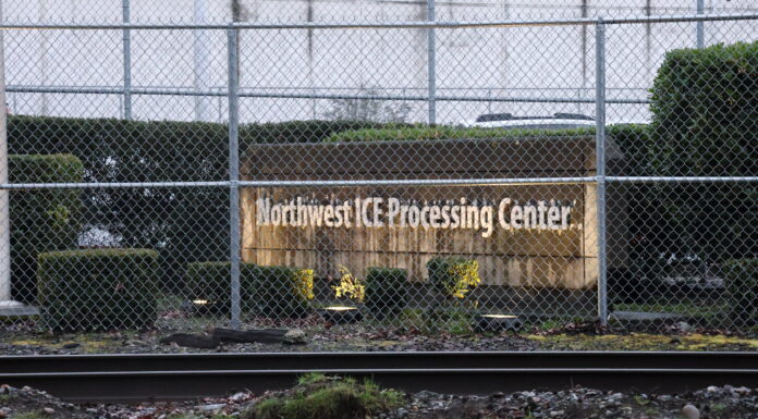 Trasladan a líderes de huelga de hambre en la cárcel migratoria de Tacoma tras protesta Vista exterior del Northwest ICE Processing Center en Tacoma, Washington, detrás de una cerca de seguridad con alambre; se observa el letrero de la instalación y vías de tren en primer plano.