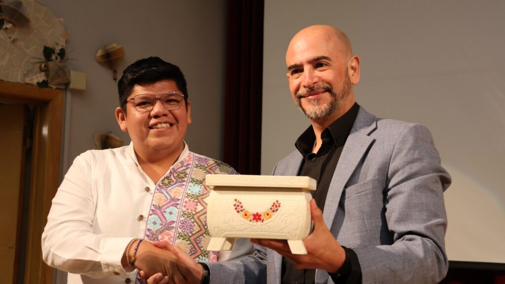 Daniel Agis Eslava entrega una artesanía al cónsul Víctor Hugo López Ortega durante el Festival Internacional de Poesía Voces del Alma. Foto: Latino Herald™.