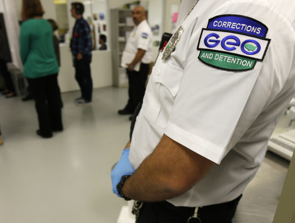 Guardia de The GEO Group con uniforme de “Corrections GEO and Detention” dentro del área de procesamiento de detenidos durante un recorrido para medios en el Northwest Detention Center en Tacoma, Washington.