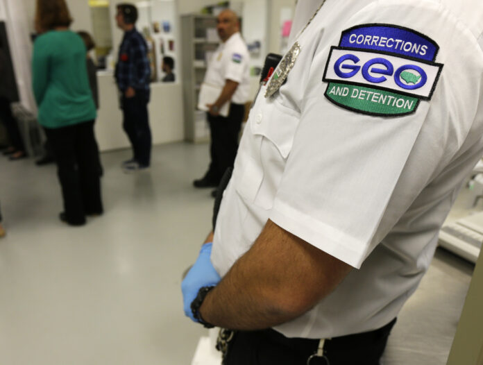 Guardia de The GEO Group con uniforme de “Corrections GEO and Detention” dentro del área de procesamiento de detenidos durante un recorrido para medios en el Northwest Detention Center en Tacoma, Washington.
