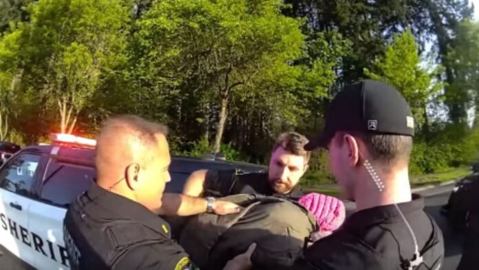 Momento en el que los agentes resguardan al bebe luego de terminar la persecución — Imagen: Oficina del sheriff del condado de Thrston