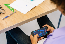 Restricciones de celulares en Escuelas Públicas de Seattle entran en vigor hoy Un niño con camiseta morada jugando con el móvil