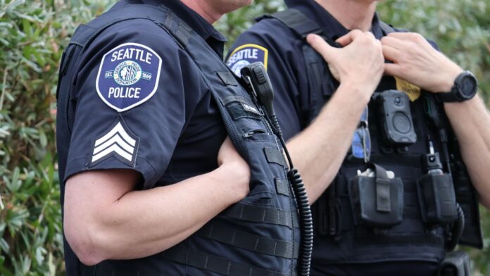 Agentes de policía de Seattle observan una manifestación en el Seattle Center en marzo de 2026 — Foto: Latino Herald ™