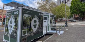 Baños públicos inteligentes llegan a Seattle antes del Mundial Módulos de baños públicos gratuitos instalados en una calle del centro de Seattle, cerca de la torre Smith Tower. Las estructuras incluyen acceso para personas con discapacidad y paneles solares en la parte superior.