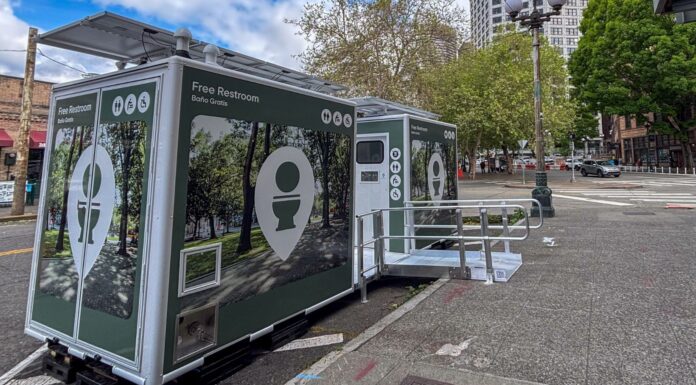 Baños públicos inteligentes llegan a Seattle antes del Mundial Módulos de baños públicos gratuitos instalados en una calle del centro de Seattle, cerca de la torre Smith Tower. Las estructuras incluyen acceso para personas con discapacidad y paneles solares en la parte superior.