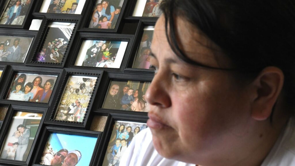Adriana Garzón, madre de Brayan Rayo Garzón, quien murió por suicidio mientras estaba bajo custodia del ICE en abril de 2025, posa frente a una colección de fotos familiares en St. Louis, el viernes 1 de mayo de 2026. (Foto AP/Nick Ingram)