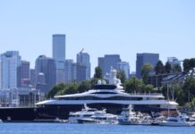 Despidos en Meta y la llegada del superyate de Zuckerberg a Seattle Vista panorámica del yate LaunchPad, asociado a Mark Zuckerberg, navegando o atracado cerca del lago Union en Seattle, con el horizonte del centro de la ciudad visible al fondo y varias embarcaciones menores en primer plano.