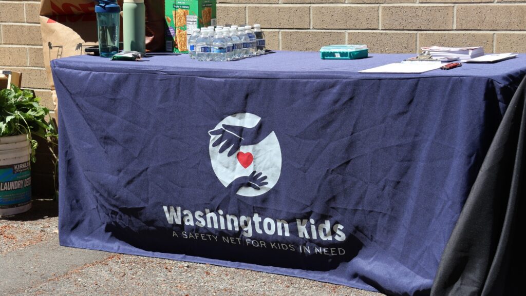 Mesa informativa de Washington Kids durante una actividad comunitaria en Scriber Lake High School.
