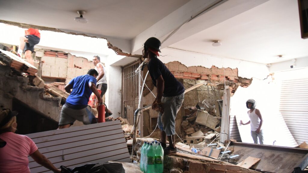 Varias personas retiran mercancías de una tienda dañada un día después de que un terremoto y varias réplicas sacudieran Catia La Mar, Venezuela, el jueves 25 de junio de 2026. (AP Foto/Jonathan Lanza)