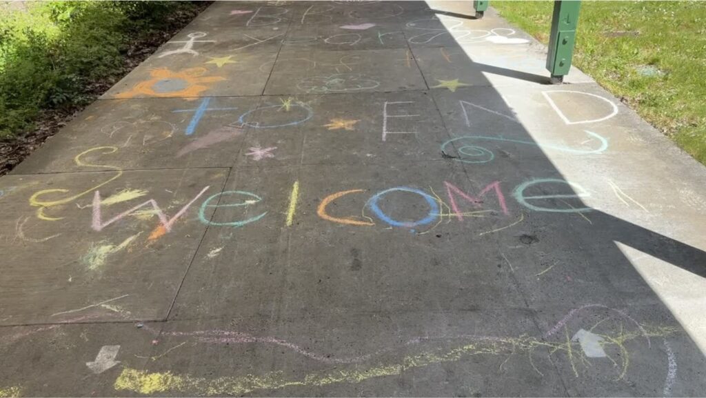 La palabra “Welcome” escrita con tizas de colores en el piso de un pasillo de la escuela Scriber Lake High School en Edmonds, WA.