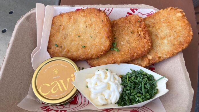 Se muestra un plato de 75 dólares llamado "Fancy AF Tots" —que contiene croquetas de papa fritas, caviar, crème fraîche y cebollino— durante un partido de la Copa del Mundo en el estadio de Miami, en Miami Gardens, Florida, el domingo 21 de junio de 2026. (Foto AP/Tim Reynolds)