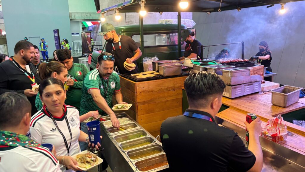 Aficionados que asistieron al partido de la Copa Mundial de fútbol entre México y Corea del Sur en Zapopan, cerca de Guadalajara, el jueves 18 de junio de 2026, compran comida en un puesto de venta dentro del estadio. (Foto AP/Tales Azzoni)
