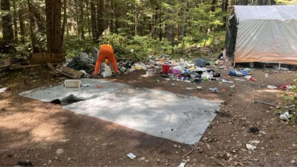 Personal trabajando para retirar la basura de un campamento ilegal ubicado cerca del inicio del sendero Slab Camp — Imagen: Oficina del sheriff del condado de Clallam  