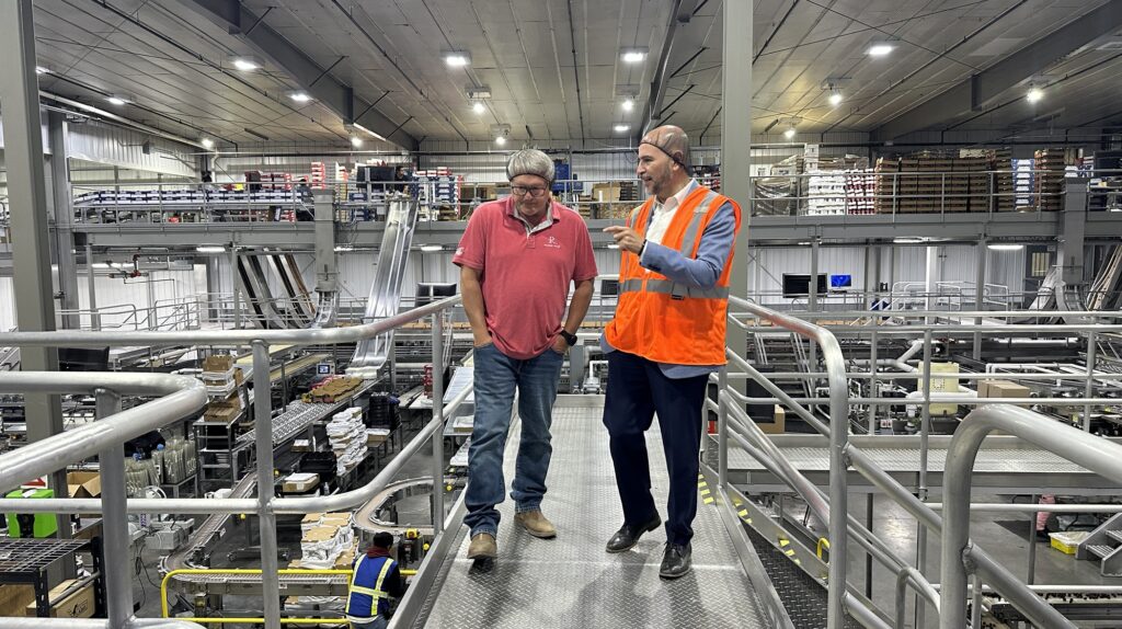 Jason Bakker, director ejecutivo de Monson Fruit, y el cónsul de México en Seattle, Víctor Hugo López Ortega, recorren una planta empacadora de cerezas en el Valle de Yakima para conocer las operaciones de procesamiento y distribución de fruta.