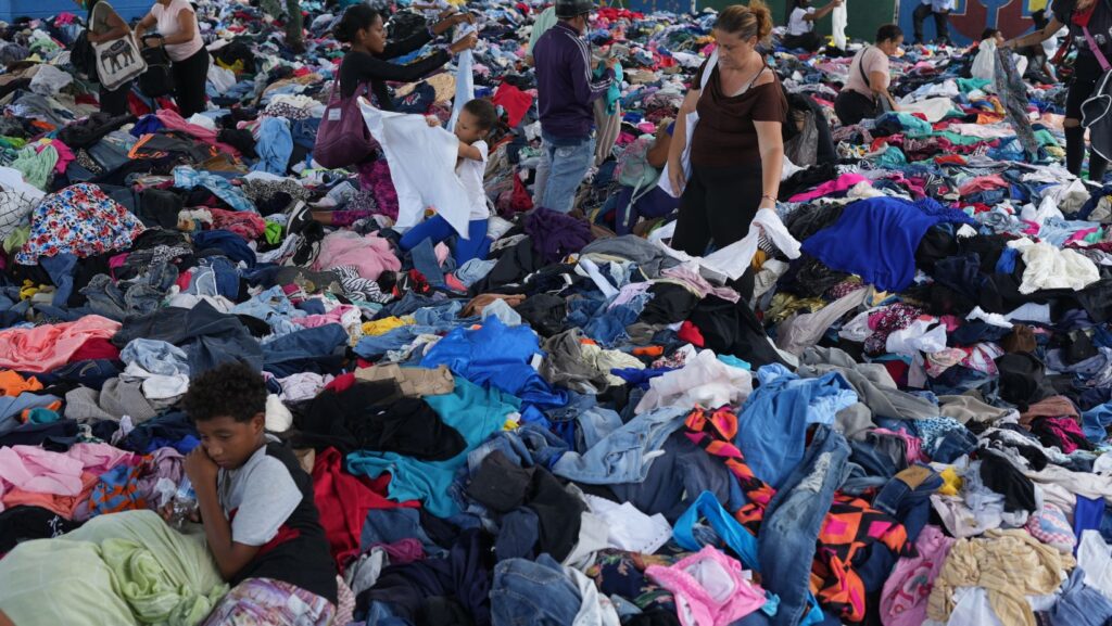 Personas eligen ropa donada para los damnificados por los terremotos en un complejo deportivo, el sábado 4 de julio de 2026, en La Guaira, Venezuela. (AP Foto/Ariana Cubillos)
