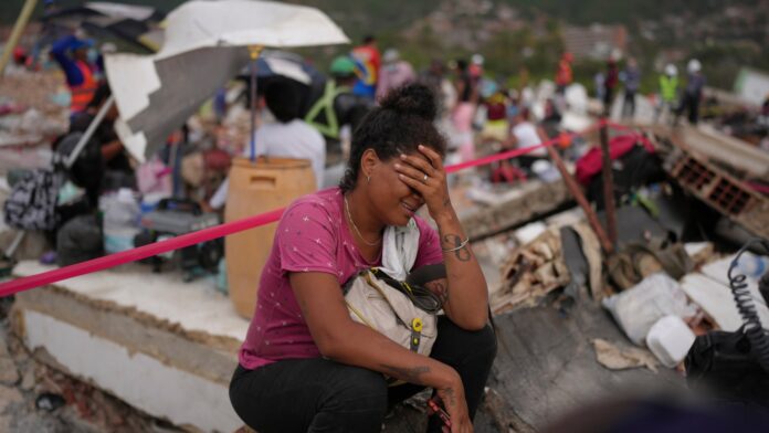Terremoto Venezuela Khaterine Roa llora mientras miembros del Departamento de Bomberos del Condado de Los Ángeles buscan sobrevivientes en un edificio que se derrumbó durante los terremotos que azotaron La Guaira, Venezuela, el martes 30 de junio de 2026. (AP Foto/Matías Delacroix)