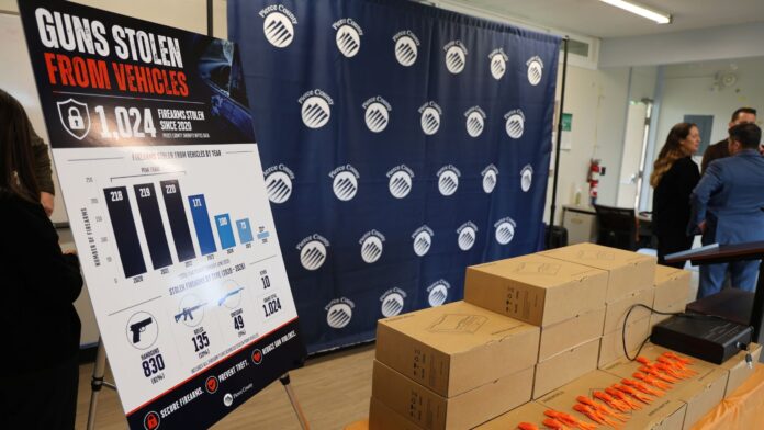 Cajas de seguridad biométricas para armas de fuego y cartel informativo sobre prevención de robos durante un evento de Pierce County en Tacoma.