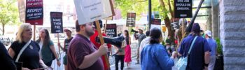 Trabajadores en huelga se manifiestan frente a la entrada de la calle King del hotel Embassy Suites Downtown Pioneer Square, en el centro de Seattle