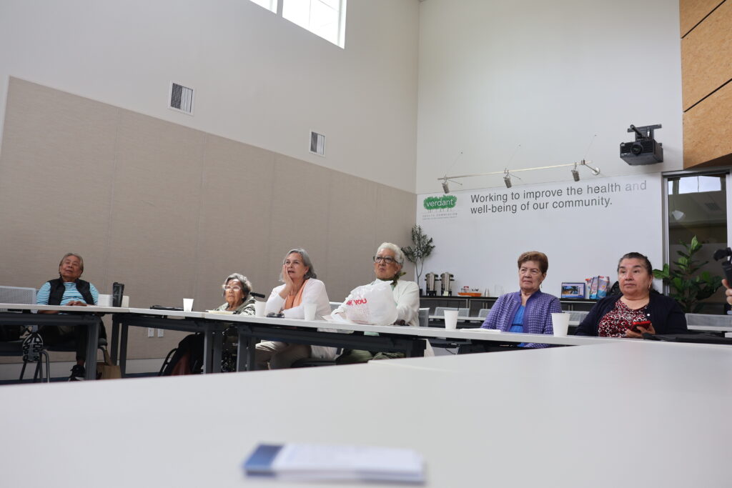 Adultos mayores del grupo hispano de Homage Senior Services participan en una presentación sobre prevención de fraudes bancarios en las instalaciones de Verdant Health Commission, en el sur del condado de Snohomish.