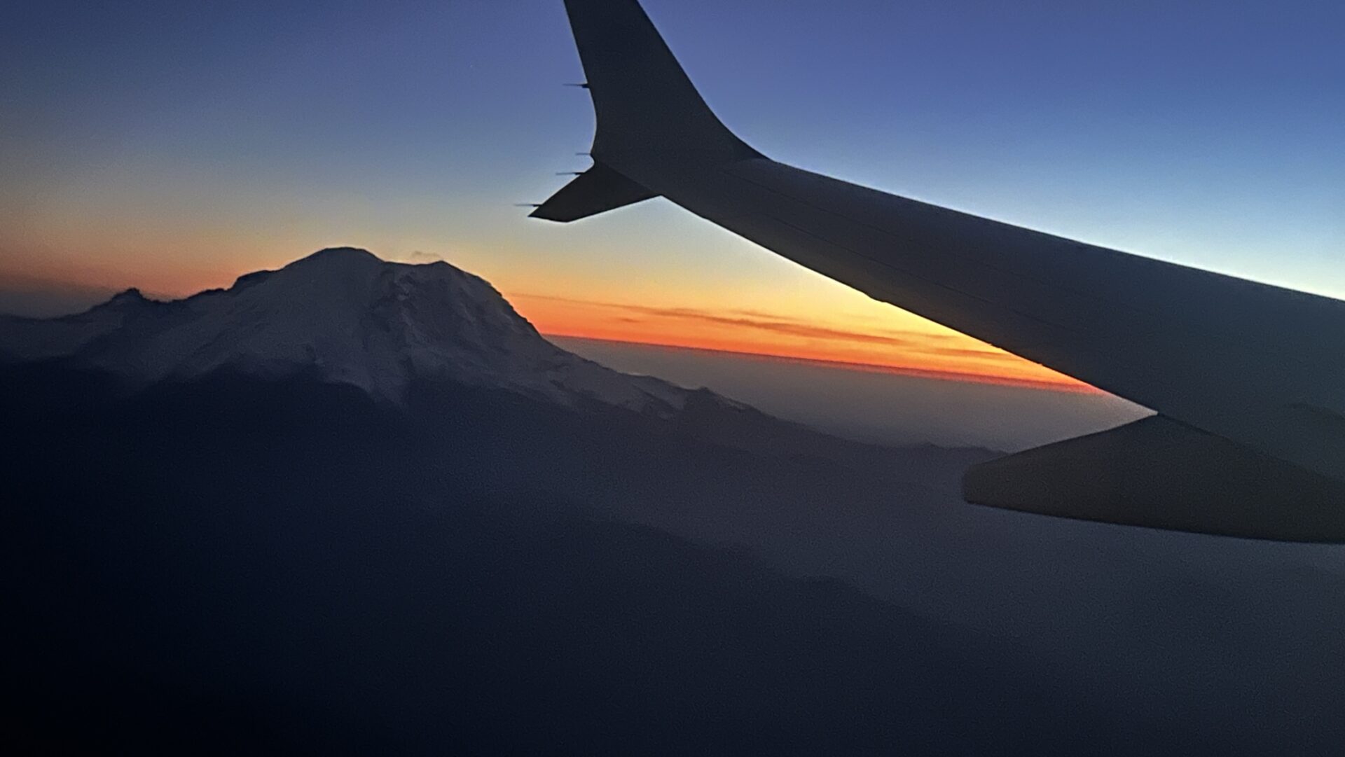 Atardecer visto desde un avión con el Mount Rainier al fondo