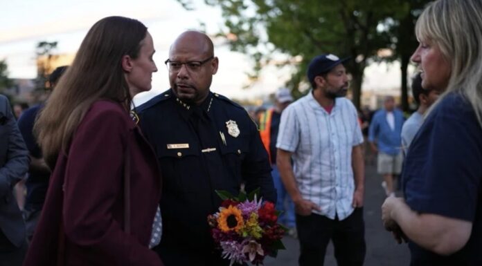 La alcaldesa de Seattle, Katie Wilson, a la izquierda, y el jefe de policía de Seattle, Shon Barnes, en el centro, asisten a la vigilia por las víctimas el día después de un tiroteo en el Seattle Center durante el festival gastronómico Bite of Seattle, el La alcaldesa de Seattle, Katie Wilson (izquierda), y el jefe de policía de Seattle, Shon Barnes (centro), asisten a la vigilia en memoria de las víctimas del tiroteo ocurrido en el Seattle Center durante el festival gastronómico Bite of Seattle, el lunes 27 de julio de 2026, en Seattle. (Foto AP/Lindsey Wasson)
