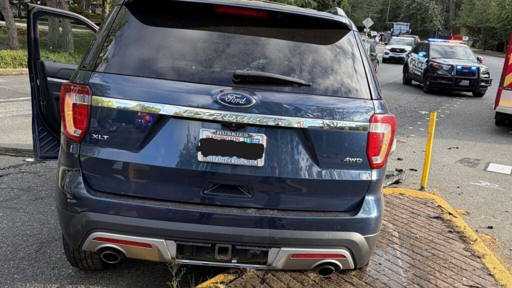 ista trasera de una camioneta Ford sobre una isleta peatonal, con vehículos policiales en la calle en Redmond.