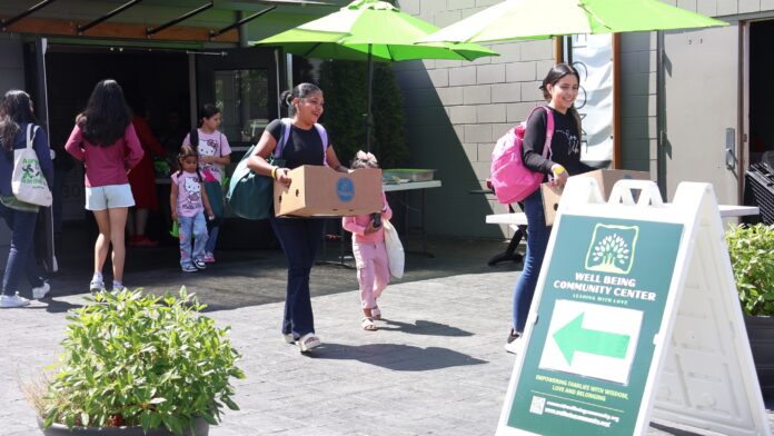 Familias reciben recursos durante evento en Lynnwood Familias salen con alimentos y otros recursos del evento organizado por Well Being Community Center en Lynnwood.