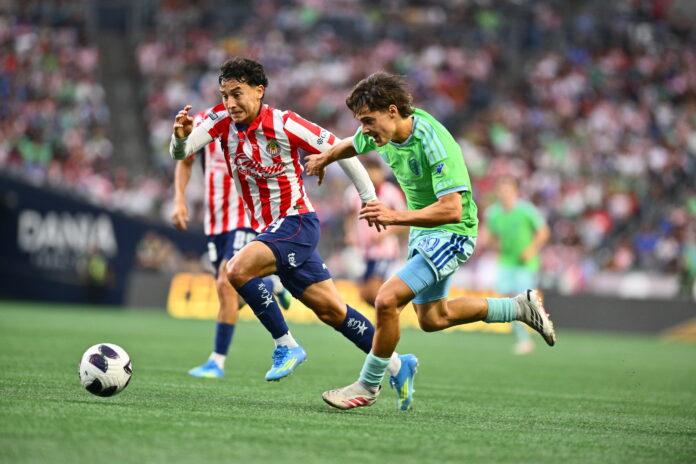 Jugador de Chivas de Guadalajara avanza con el balón mientras un futbolista de Seattle Sounders intenta alcanzarlo durante el partido de la Leagues Cup 2026 en el Lumen Field de Seattle.