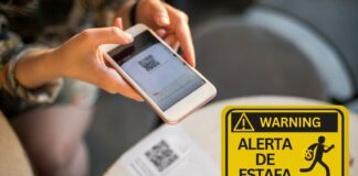 Advierten sobre multas falsas con códigos QR en vehículos Persona escanea con un teléfono un código QR colocado en un aviso, junto a una señal amarilla que advierte sobre una estafa.