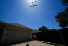Amazon ampliará a 500 ciudades reparto de paquetes ligeros con drones Julep Toth, de 9 años, espera a que un dron deje una entrega en su casa el jueves 31 de julio de 2025 en Frisco, Texas. (Foto AP/Julio Cortez)