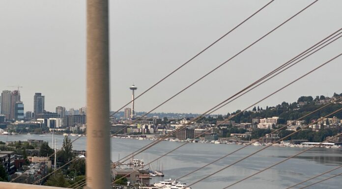 Alerta por mala calidad del aire en varios condados mientras aumenta el calor en WA Vista panorámica de Seattle con la Space Needle al fondo, parcialmente cubierta por una capa de humo proveniente de los incendios forestales, lo que reduce la visibilidad y evidencia el deterioro de la calidad del aire.