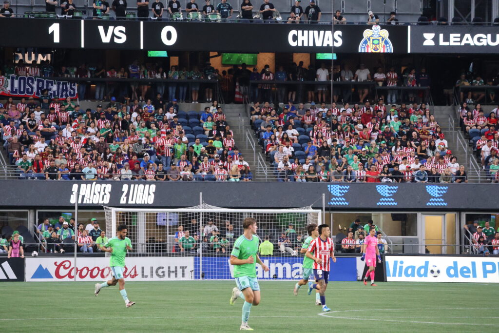 Jugadores de Seattle Sounders y Chivas de Guadalajara disputan el partido en el Lumen Field, con aficionados de ambos equipos en las gradas durante la Leagues Cup 2026.