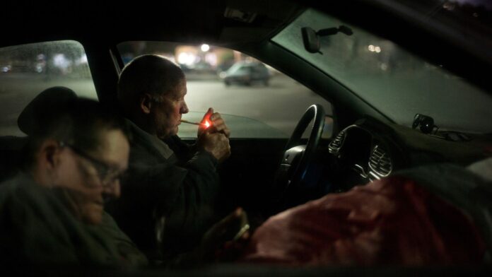 Indigentes en su auto Dos personas sin hogar están sentadas en el pequeño automóvil donde duermen por las noches, en el estacionamiento de una tienda Walmart (Foto AP/Jae C. Hong)