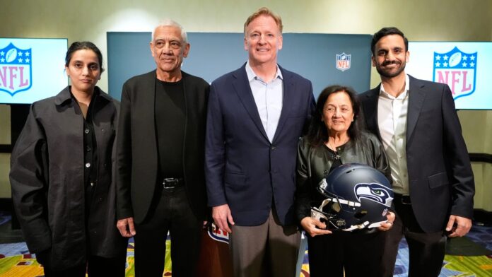 La familia Khosla —propietaria de los Seattle Seahawks— y el comisionado de la NFL, Roger Goodell posan para una fotografía durante una conferencia de prensa en una reunión de propietarios de la NFL celebrada el miércoles 26 de agosto de 2026 en Atlanta. (Foto AP/Brynn Anderson)