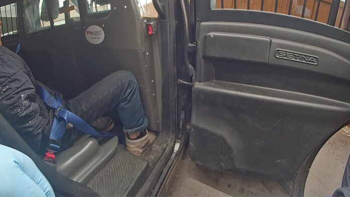 Longview police 1 Hombre arrestado permanece sentado en la parte trasera de un vehículo policial en Longview, Washington.