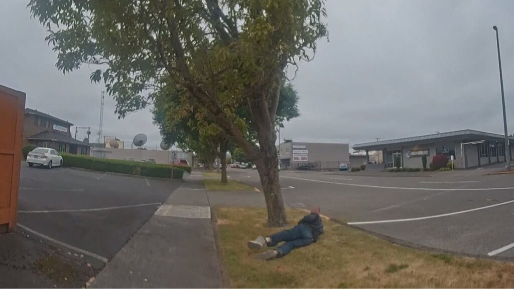 t: Hombre permanece en el suelo mientras un agente de la Policía de Longview se aproxima durante un incidente en Longview, Washington.