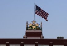 Starbucks reporta 224 despidos vinculados a su sede de Seattle Letrero de Starbucks y bandera de Estados Unidos en la parte superior de la sede de la compañía en Seattle.