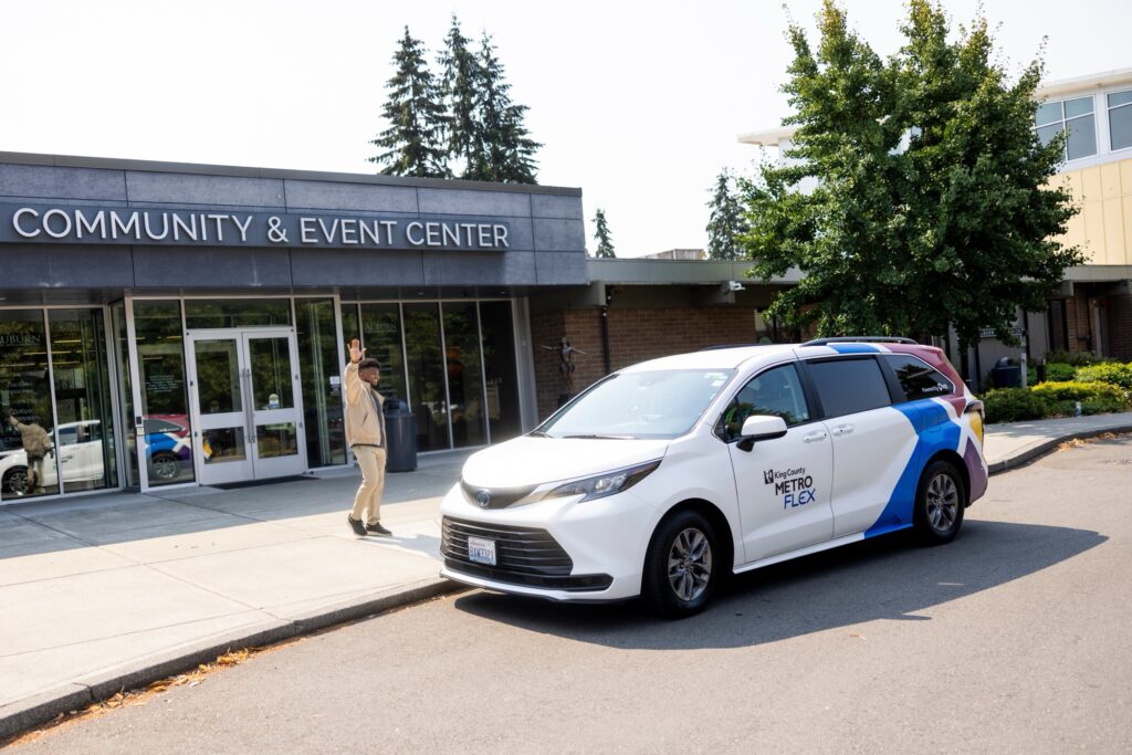 Vehículo de King County Metro Flex estacionado frente a un centro comunitario y de eventos en el área de Auburn y Federal Way, Washington.