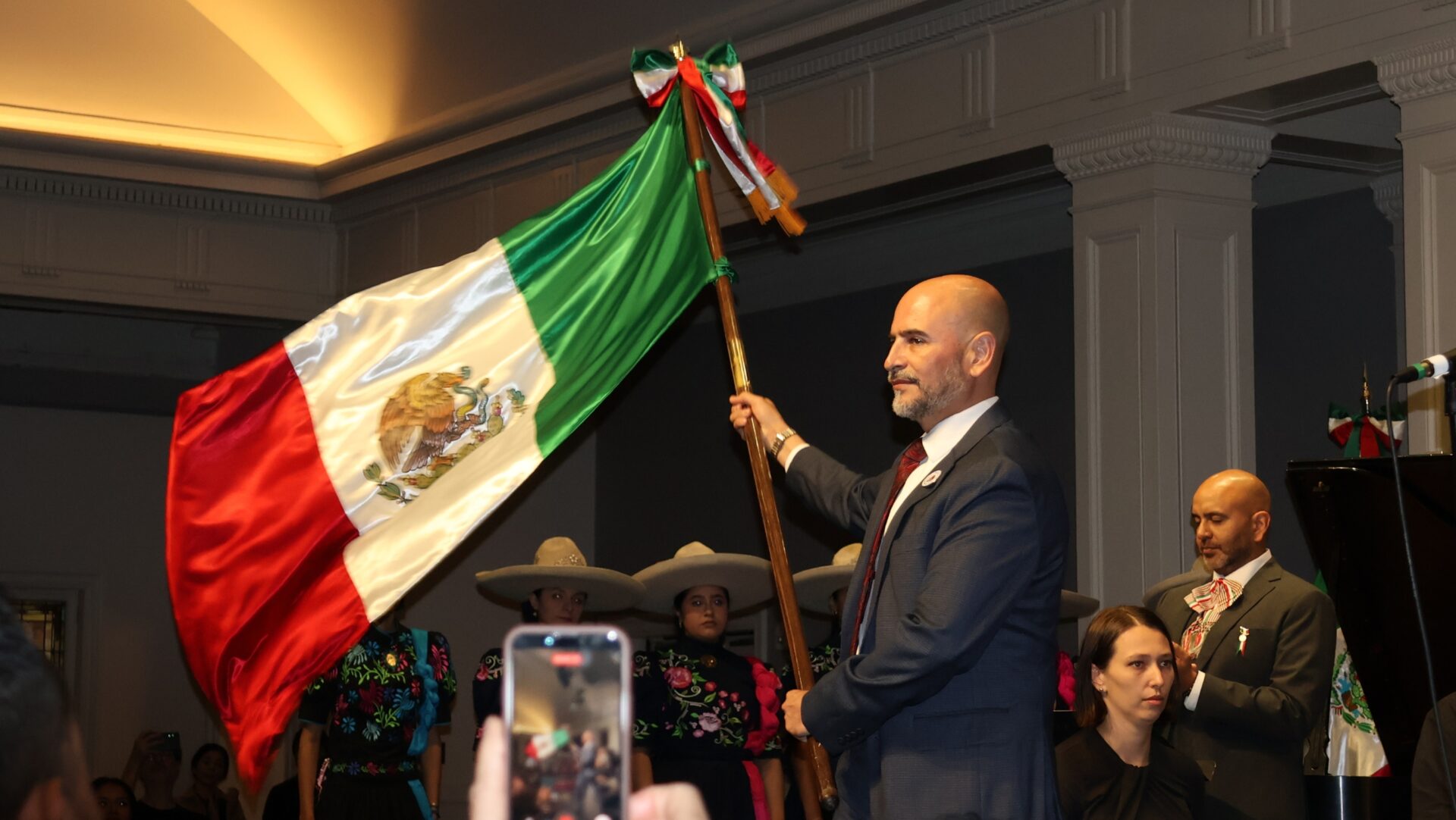 Víctor Hugo López Ortega sostiene la bandera de México durante la ceremonia del Grito de Independencia en Town Hall Seattle.