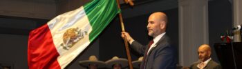 Víctor Hugo López Ortega sostiene la bandera de México durante la ceremonia del Grito de Independencia en Town Hall Seattle.