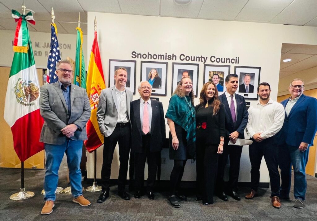 Representantes y funcionarios posan junto a las banderas de México, Estados Unidos, Washington y España durante la celebración del Mes de la Herencia Hispana en el Condado de Snohomish.