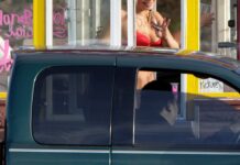 70 bikini baristas ganan demanda por robo de salarios en WA Una barista de un puesto de café tipo "Bikini Hut" sostiene dinero mientras atiende a un cliente. (Foto AP/Ted S. Warren, archivo)