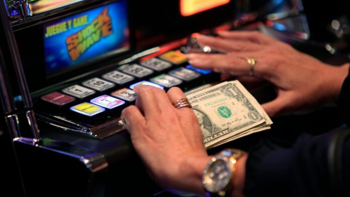 En esta fotografía de archivo, un cliente juega en una máquina tragamonedas en el interior de un casino. (Foto AP/Wilfredo Lee)