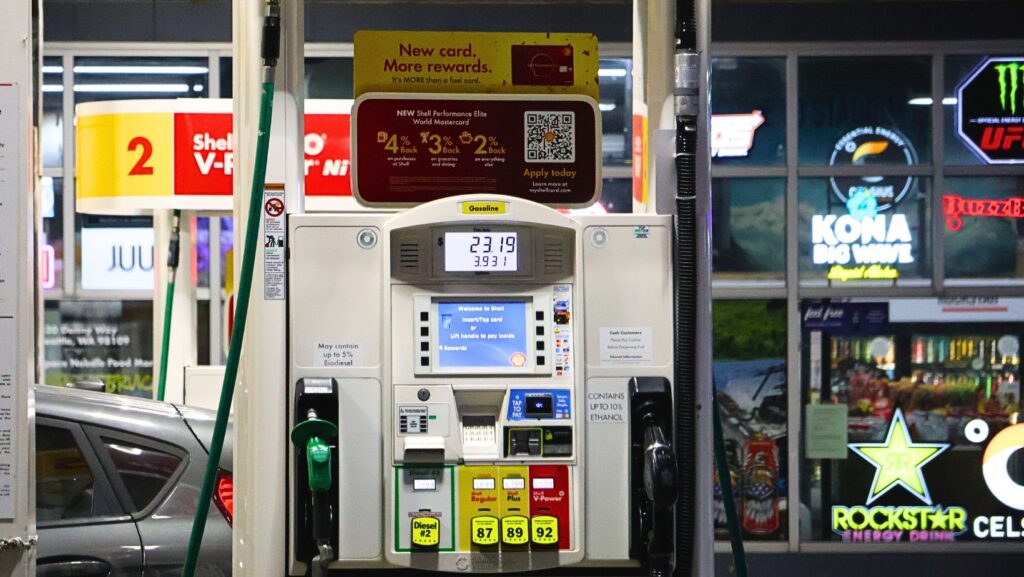 Bomba de combustible en una estación Shell muestra una compra de gasolina mientras se observan las mangueras para gasolina y diésel.
