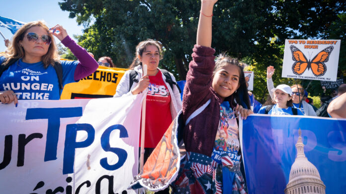 Marilyn Miranda, de 12 años, levanta la mano durante una protesta en Washington para pedir una extensión del Estatus de Protección Temporal (TPS), frente a la Casa Blanca, el 23 de septiembre de 2022.