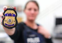 Denunciante de ICE revela severas fallas en la contratación de nuevos agentes Una agente de U.S. Immigration and Customs Enforcement (ICE) muestra en primer plano una insignia oficial de la agencia.
