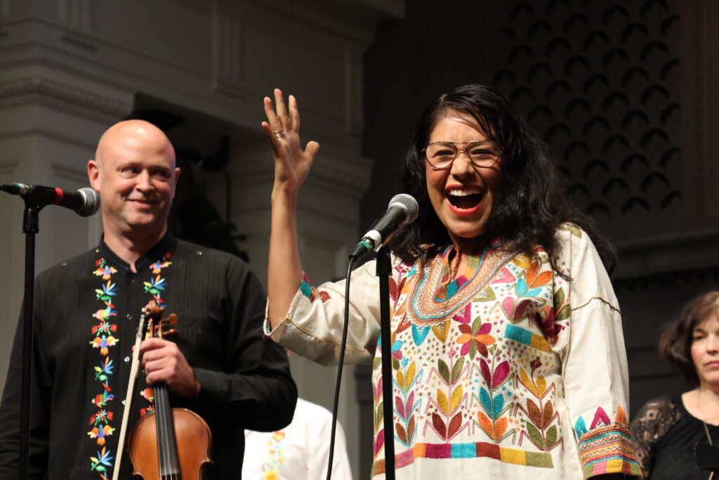 Paula Madrigal dirige a la Ballard Civic Orchestra durante el concierto de El Grito 2026 en Town Hall Seattle.